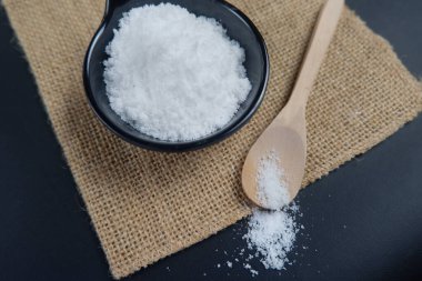 Masadaki tahta kaşıkta deniz tuzu. Deniz tuzu tatlandırmak, yiyecekleri korumak ve güzellik tedavisini tuzla ovalamak için kullanılır..