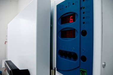 Kuru sıcak sterilizatörünün kapısı, modern bir klinikte tıbbi aletleri işliyor.
