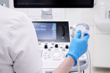 Yakın plan - bir doktorun elinde ultrason dönüştürücü tutarken görüntüsü