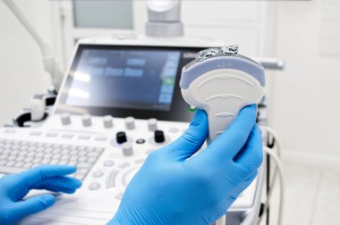 Yakın plan - bir doktorun elinde ultrason dönüştürücü tutarken görüntüsü