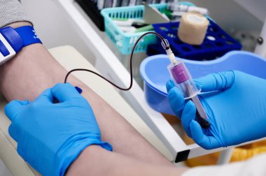 Doktor klinikteki hasta için kan testi yapıyor.