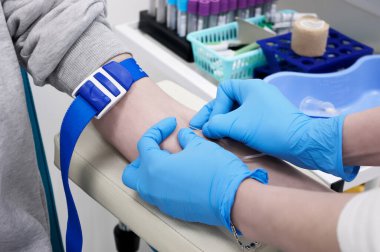 Doktor klinikteki hasta için kan testi yapıyor.