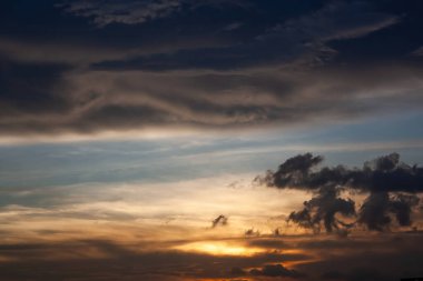 Gökyüzünde yükseklerde uçan bir uçak, nefes kesici bir günbatımı tarafından çerçevelenmiş canlı renklerle harmanlanmış güzel.