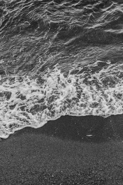 Hersonissos sahilinde siyah beyaz dalgalar.