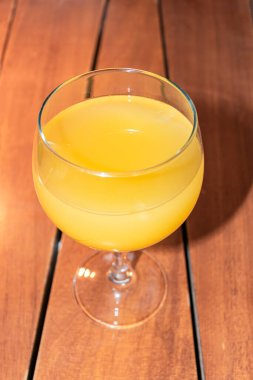 Girit Yunan restoranında ahşap arka planda servis edilen sarı ananas suyu 