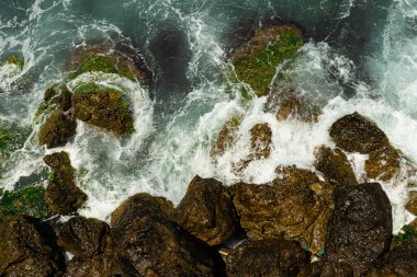 Okyanus dalgası kıyıya vurur beyaz hava kabarcığı yaratır