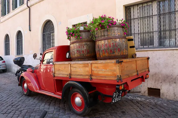 Roma, İtalya - 29 Temmuz 2019: Klasik Fiat vintage 1100 ELR kırmızı kamyonet ve Trastevere bölgesinde park etmiş iki tahta varil.