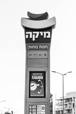 Eilat, Israil - 1 Kasım 2024: Mika benzin istasyonu ve market ilanı siyah beyaz. Eilat, İsrail vergisiz pahalı benzin fiyatları