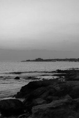 Paphos Kalesi 'nin (Ortaçağ Kalesi) gün batımı manzarası limanın karşısından siyah beyaz olarak görülüyor.