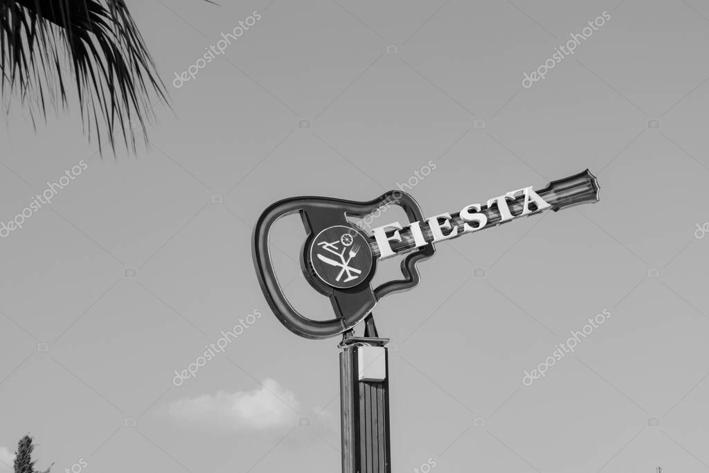 Paphos, Cyprus- September 5, 2023: Fiesta Bar & Grill cocktail bar restaurant guitar symbol near hotel strip promenade in black and white