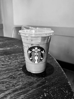 Nuremburg, Almanya - 2 Mayıs 2025 Starbucks soğuk kahve fincanı siyah beyaz ahşap masada oturuyor.