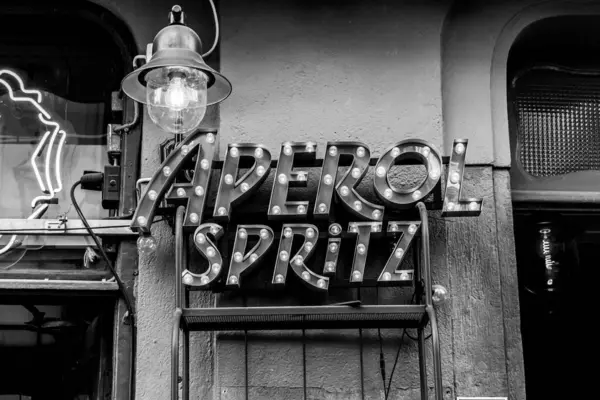 Aperol Spritz (spritz veneziano) siyah ve beyaz tabanlı popüler bir İtalyan şarabı kokteyli imzalar.