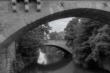 Hallertor Köprüsü (Hallertorbrucke) Nuremberg 'in Eski Kasabası' nın batı yakasındaki Pegnitz Nehri üzerindeki bir kemer köprüsü Kettensteg yaya köprüsünden siyah beyaz olarak görüntülendi.