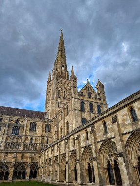 Norwich Katedrali: Görkemli Gotik Yapı. Norwich Katedrali 'nin nefes kesici manzarası etkileyici Gotik mimarisini, yükselen kulelerini ve karmaşık taş işçiliğini gözler önüne seriyor. Dramatik gökyüzü, bu tarihi mekanın ihtişamını artırıyor..