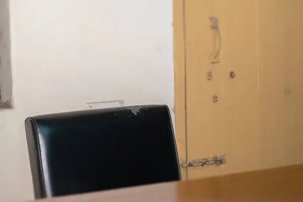 Ofis odası, arka planda sandalye ve masa sarı kapısı var.