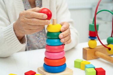 Asyalı yaşlı bir kadın, geliştirme oyunu oynuyor..