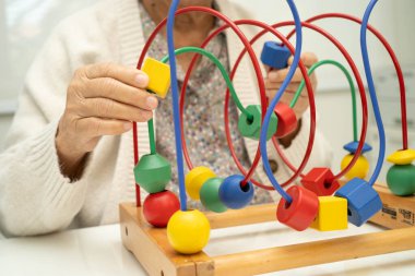 Asyalı yaşlı bir kadın, geliştirme oyunu oynuyor..