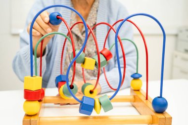 Asyalı yaşlı bir kadın, geliştirme oyunu oynuyor..