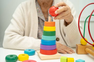 Asyalı yaşlı bir kadın, geliştirme oyunu oynuyor..