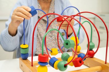 Asyalı yaşlı bir kadın, geliştirme oyunu oynuyor..