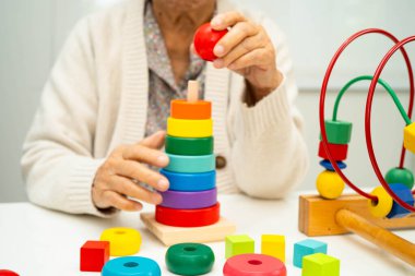 Asyalı yaşlı bir kadın, geliştirme oyunu oynuyor..