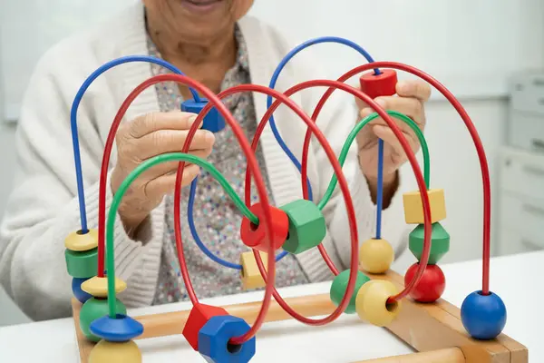 Asyalı yaşlı bir kadın, geliştirme oyunu oynuyor..