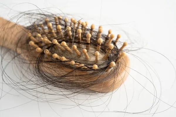 Tarak fırçasıyla beyaz arkaplanda saç kaybı.