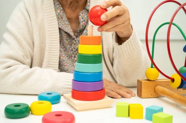 Asyalı yaşlı bir kadın, geliştirme oyunu oynuyor..