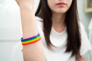 Gökkuşağı bilekliği takan Asyalı LGBT kadını.