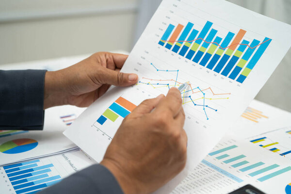 Азиатская деловая женщина, работающая с финансовым графом.