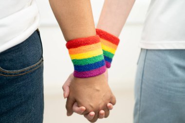 Gökkuşağı bilekliği takan Asyalı LGBT çifti..