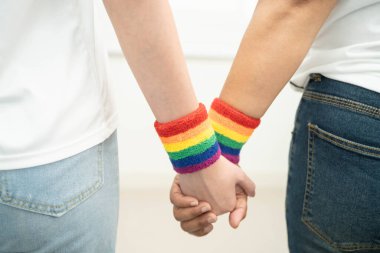 Gökkuşağı bilekliği takan Asyalı LGBT çifti..