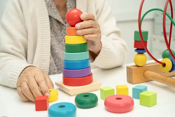 Asyalı yaşlı bir kadın, geliştirme oyunu oynuyor..