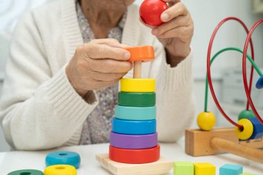 Asyalı yaşlı bir kadın, geliştirme oyunu oynuyor..