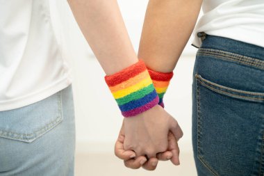 Gökkuşağı bilekliği takan Asyalı LGBT çifti..