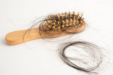 Tarak fırçasıyla beyaz arkaplanda saç kaybı.