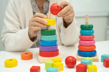 Asyalı yaşlı bir kadın, geliştirme oyunu oynuyor..