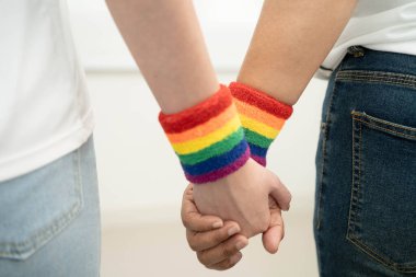 Gökkuşağı bilekliği takan Asyalı LGBT çifti..