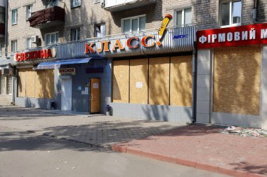  Mağazanın camları kontrplakla kaplı, onları muhtemel bombadan korumak için..