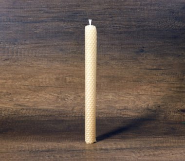 Bükülmüş yüzeyi ile aydınlatılmamış neşeli bir mum tasvir edilir.