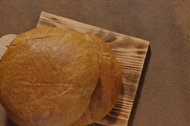 Mutfak tahtasındaki iki somun ekmeğin en üst görüntüsü.