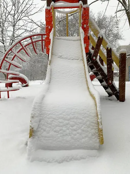 Nisan kar fırtınasından sonra karla kaplı ağaçlar. Dışarıdaki bankta ve çocuk parkında kar.