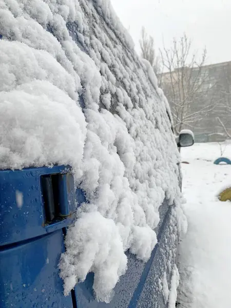 Kar fırtınası sonrası kar ve buzla kaplı bir araba..