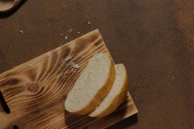 Mutfak tahtasının üzerinde dilimlenmiş bir somun ekmek resmi
