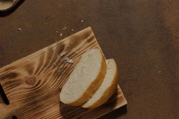 Mutfak tahtasının üzerinde dilimlenmiş bir somun ekmek resmi
