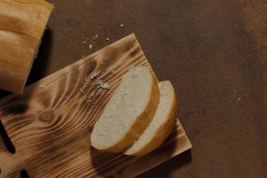 Mutfak tahtasının üzerinde dilimlenmiş bir somun ekmek resmi