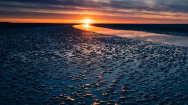 Geniş, mavimsi bir plajın üzerinde güzel, karanlık gün batımı, Baie de Somme, Fransa