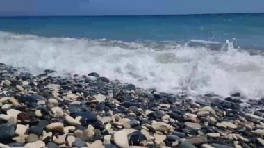 Kıbrıs. Kayalık bir plaj dalgalarla yıkanır. Yüksek kalite 4k görüntü