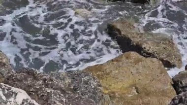 Kıbrıs. Deniz dalgaları kayalık kıyı şeridini yıkıyor. Yüksek kalite 4k görüntü