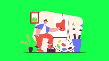 Masasında boya fırçası olan genç adam.